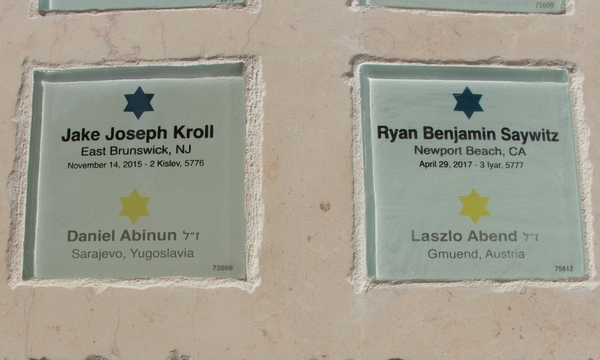Plaques bearing the names of modern bar\bat mitzvah celebrants, together with the name of a forgotten child. Photo: Yoav Devir