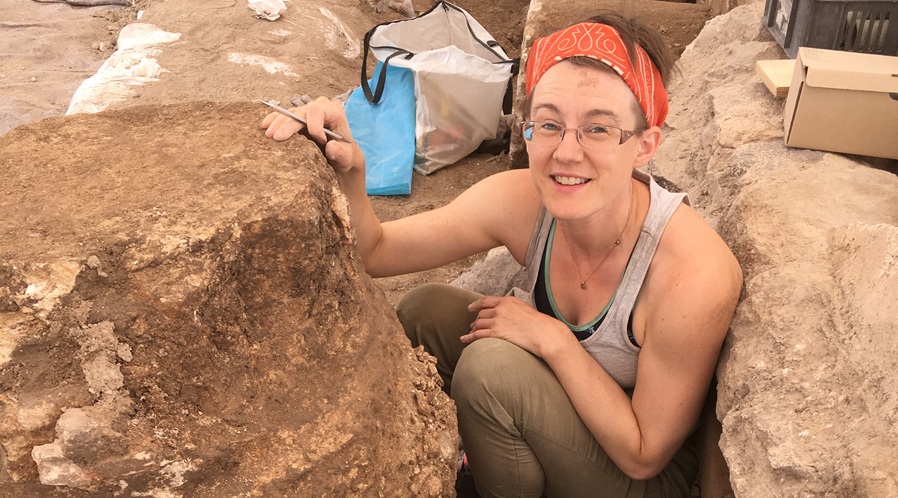 Shayna O'Connell examining painted plaster (fresco) preserved on the base of a synagogue column. Photo: Jim Haberman, Huqoq Excavation Project
