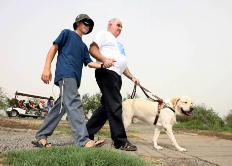 A blind visitor getting assistance and guidance at the Hula Lake. Photograph: Dror Artzi