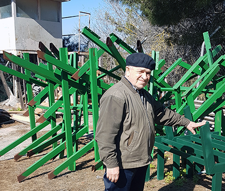 The volunteer Tzvi Hersch, next to metal structures to be installed in the forest.  Photo: Mira Zar. 